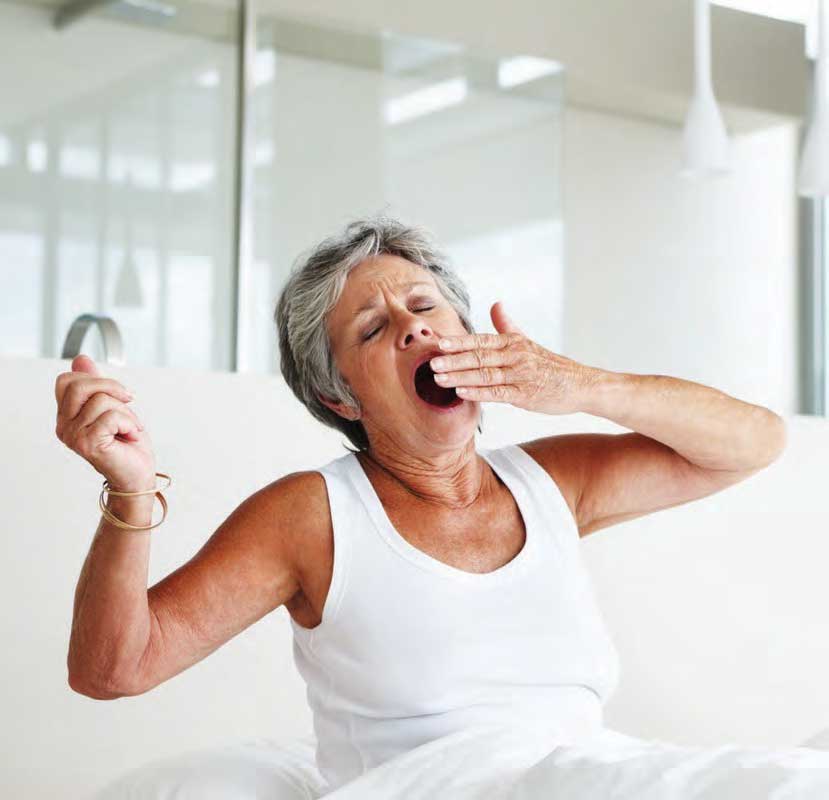 Retired woman waking up and yawning