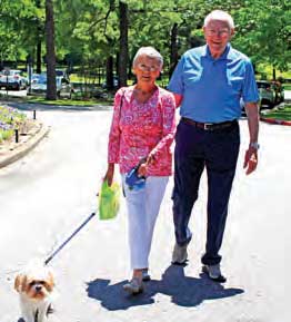 Retired couple walking their dog.
