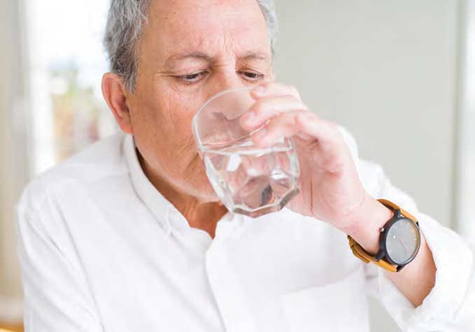 Retired man drinking water