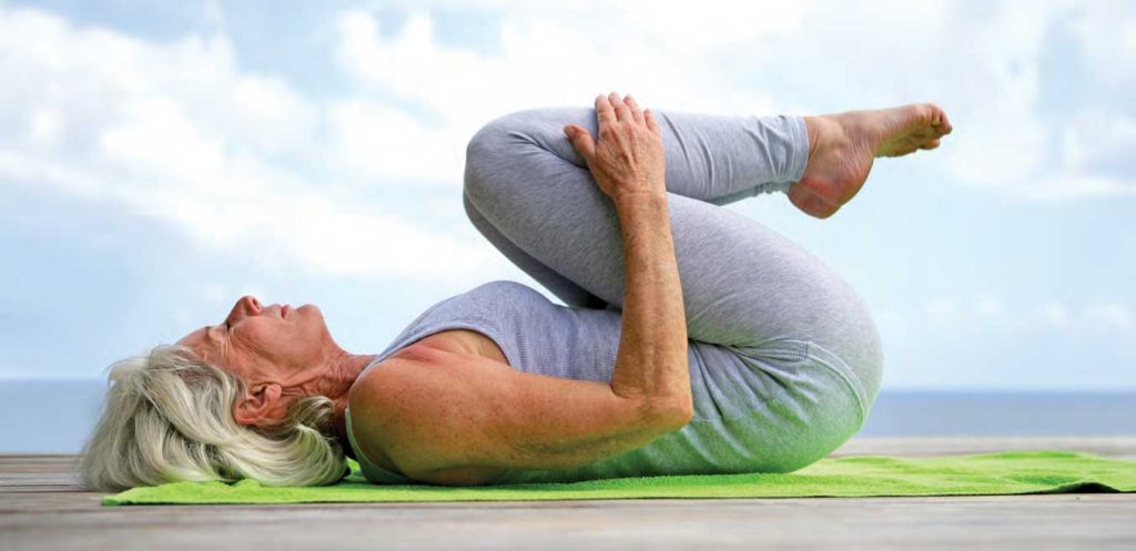 Retired woman practicing yoga.