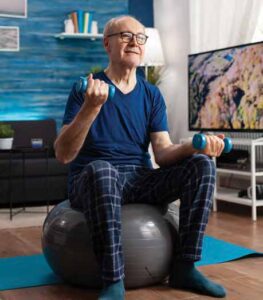 man lifting weights on an exercise ball