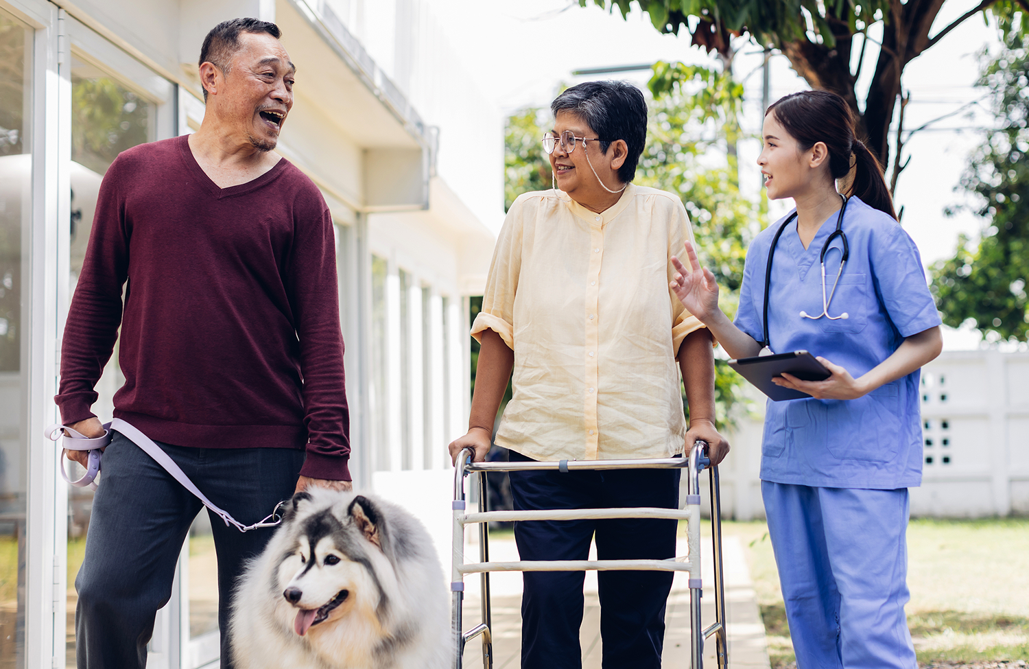 Senior with in home care workers outside walking a dog
