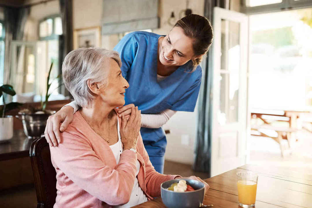 Care taker embracing woman sitting down