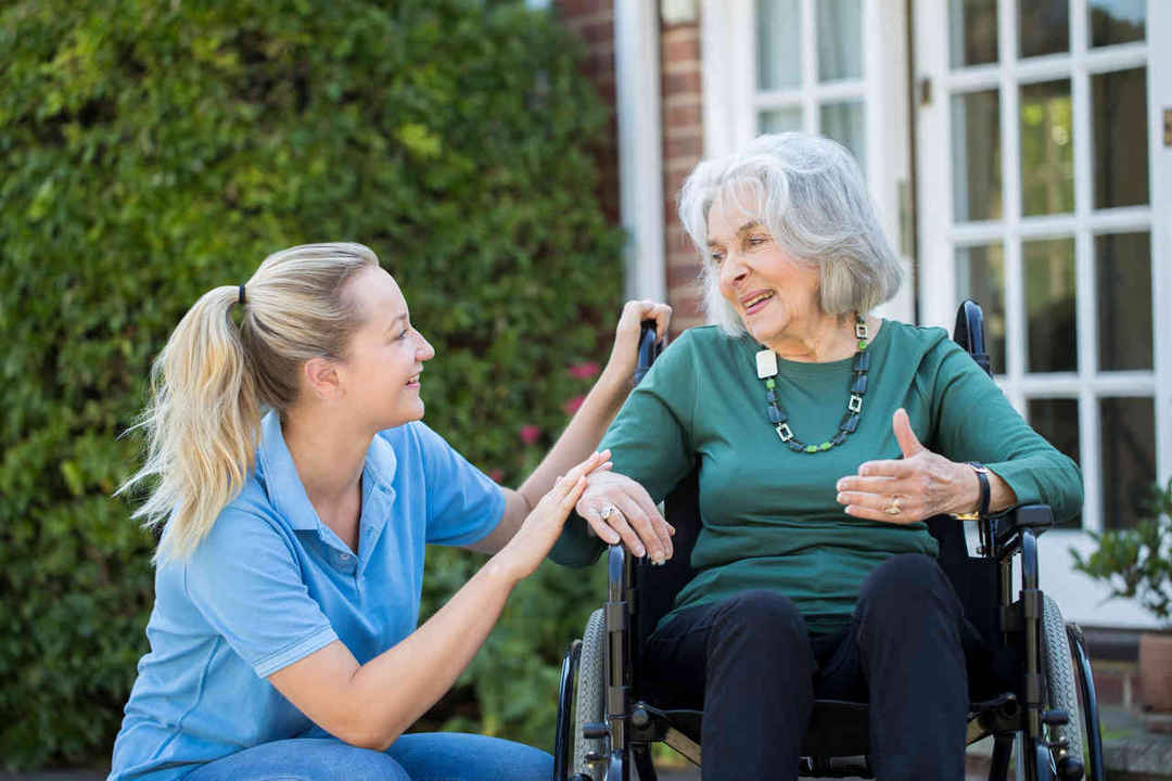 Care taker with woman in wheelchair outside