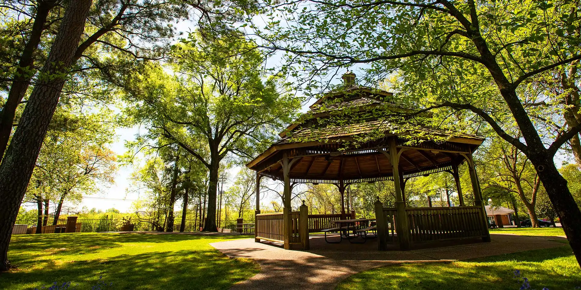 gazebo surrounded by trees shaded by the sun