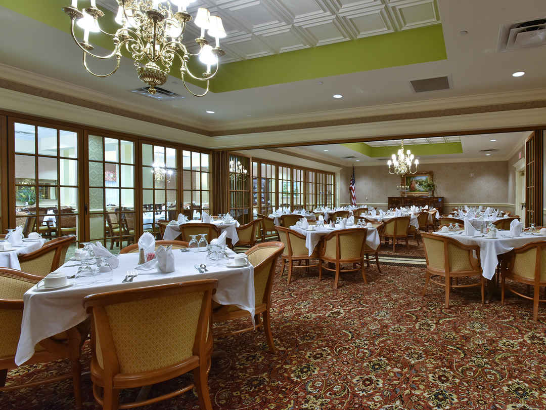 Photo of large dining room with a wall of windows from the outside
