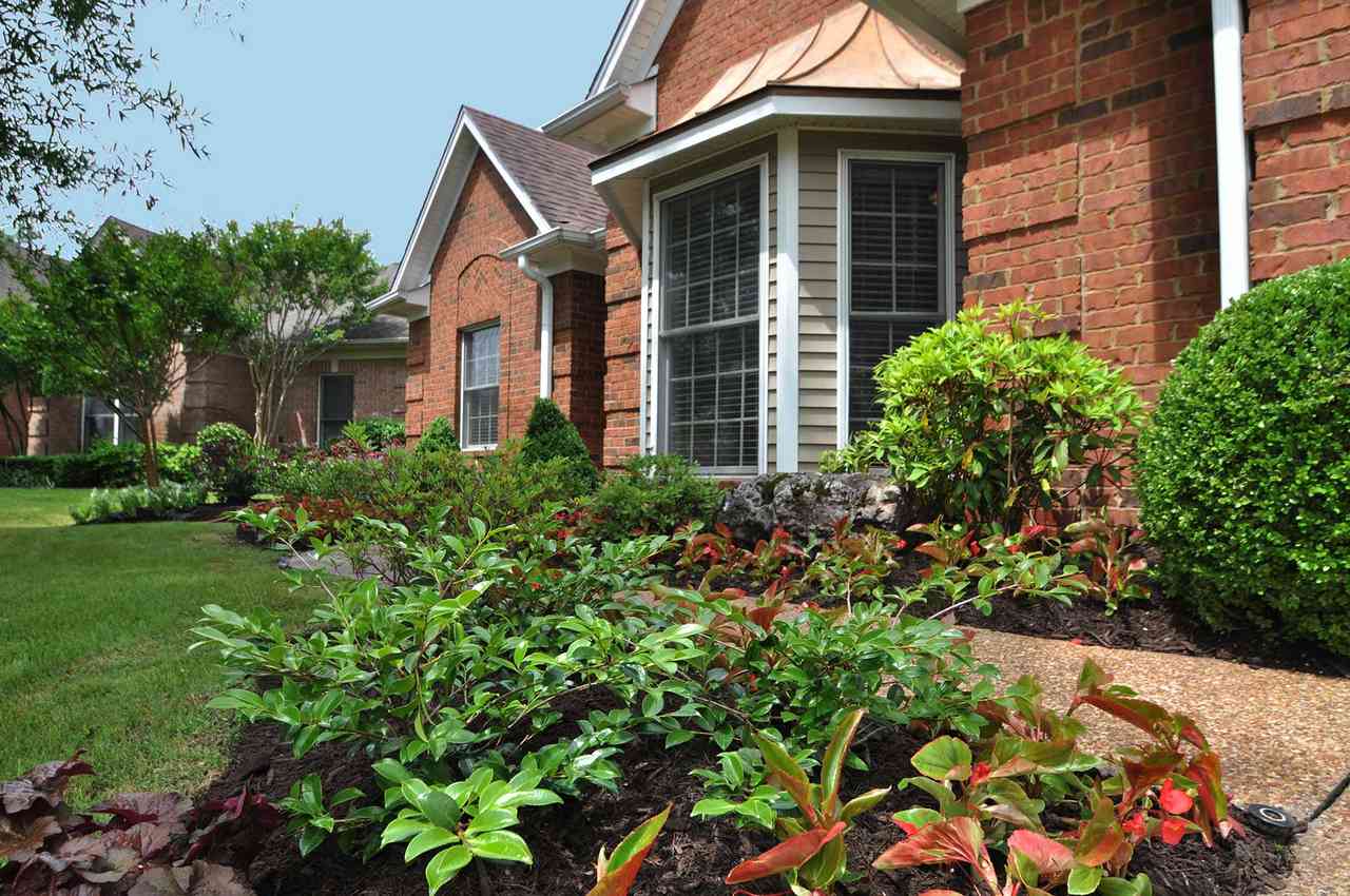 exterior of a garden home with plants and flowers in the surrounding mulch beds