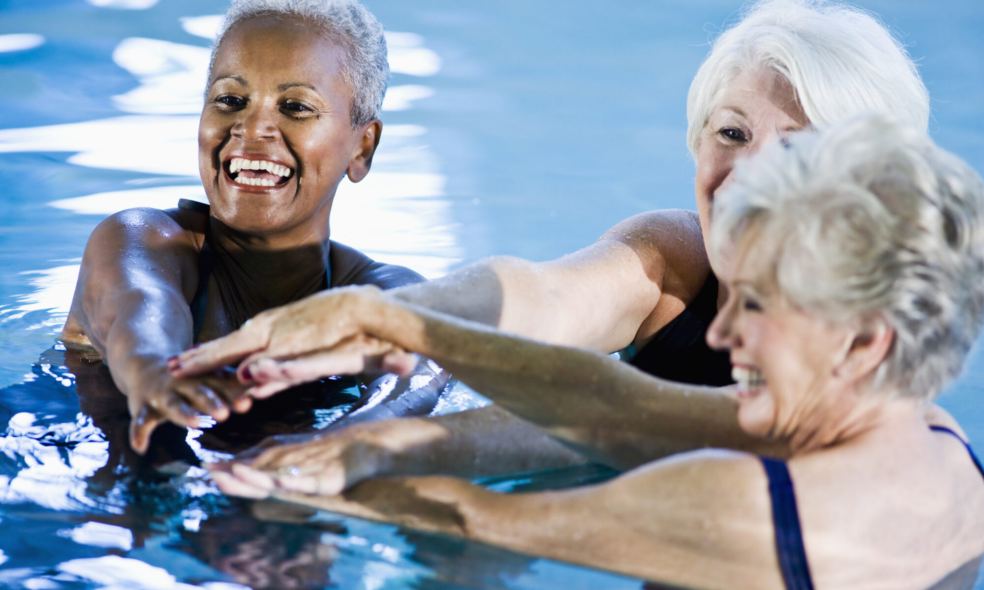Group of older women enjoying water aerobics together.