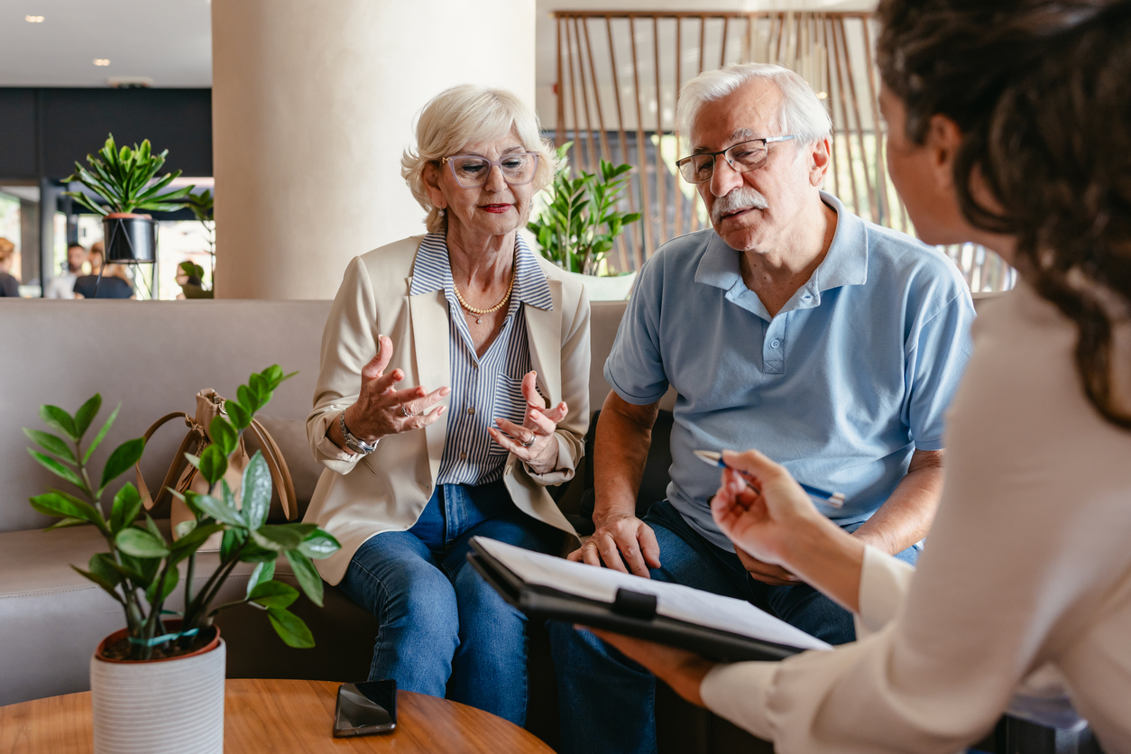 Older couple talks with a senior living advisor about the types of CCRC contracts.