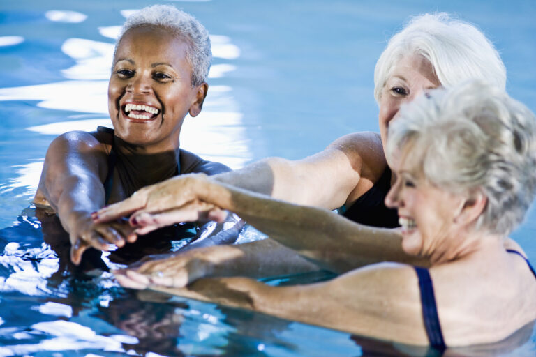 Group of older women enjoying water aerobics together.