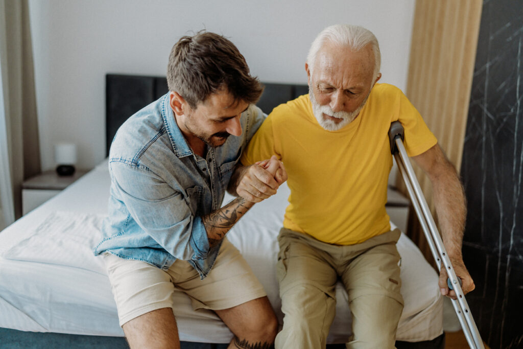 Son helps father transfer from bed during stroke recovery